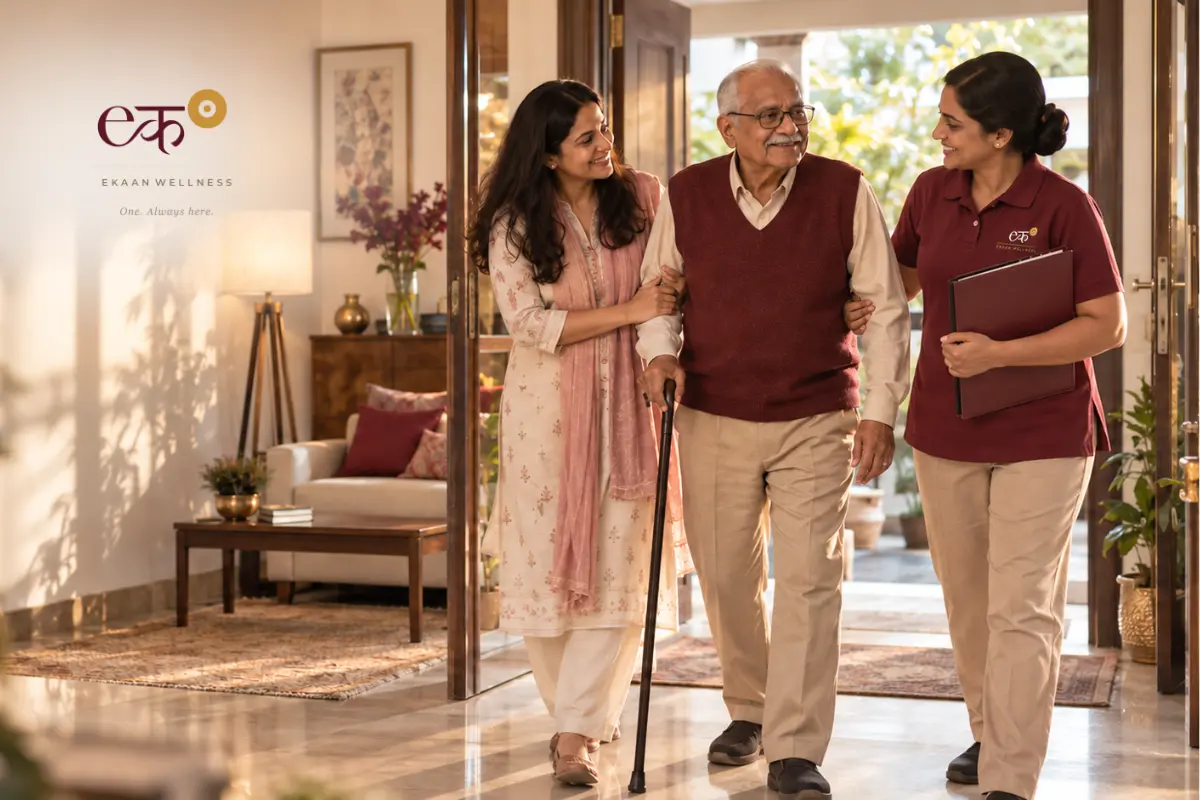 An older man using a walking stick with support from a family member and an Ekaan Wellness Care Manager at home.